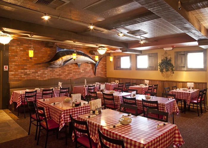Dining room booths beside a brick wall with a wine display